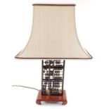 A Chinese abacus form table lamp, raised on a wooden base, with shade, 59cm high.