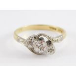 An 18ct gold and diamond three stone ring, illusion set in a crossover design, size N, 2.6g.