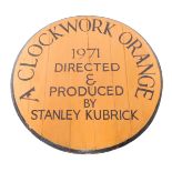 A painted circular wooden table top or wall plaque, painted with "A Clockwork Orange 1971, directed