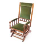 An American late 19thC beech rocking chair, upholstered in green velour.