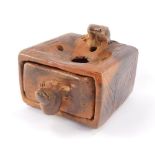 A rustic terracotta ashtray, carved with frogs, the top with holes over an ash drawer, 8.5cm wide.