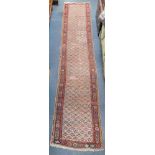 A Caucasian cream ground runner, decorated with floral motifs within geometric borders, 532cm x 108c