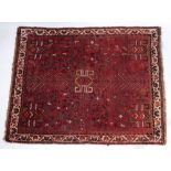 A Caucasian red ground rug, decorated with geometric motifs, 150cm x 120cm.