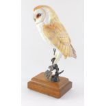 A David Friar porcelain figure of a barn owl, for Royal Worcester, modelled on a metal branch and wo