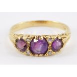 An 18ct gold and amethyst three stone ring, set with pairs of diamonds at intervals, size R, 4.8g.