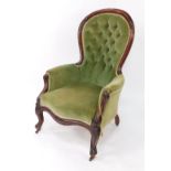 A Victorian mahogany spoon back armchair, upholstered in button back green velour, raised on cabri
