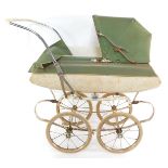 A Tri-ang coach built doll's pram, with a cream and green body, white interior and green folding hoo