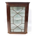 A Georgian mahogany wall hanging corner cupboard, the out swept pediment over an astragal glazed doo