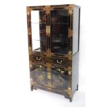 A Chinese black and gilt lacquer display cabinet, with glass panelled doors and sides enclosing two