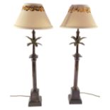 A pair of patinated metal table lamps, of column form, with leaf casting to the top, raised on stepp