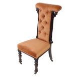 A Victorian rosewood prie dieu chair, upholstered in button back peach velour, raised on turned legs