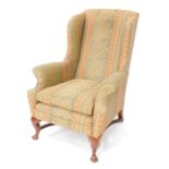 A Georgian style mahogany wing back armchair, upholstered in floral pattern and striped fabric, rais