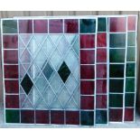 Four stained glass panels, each with red and green outer square border with diamond shaped centre, w