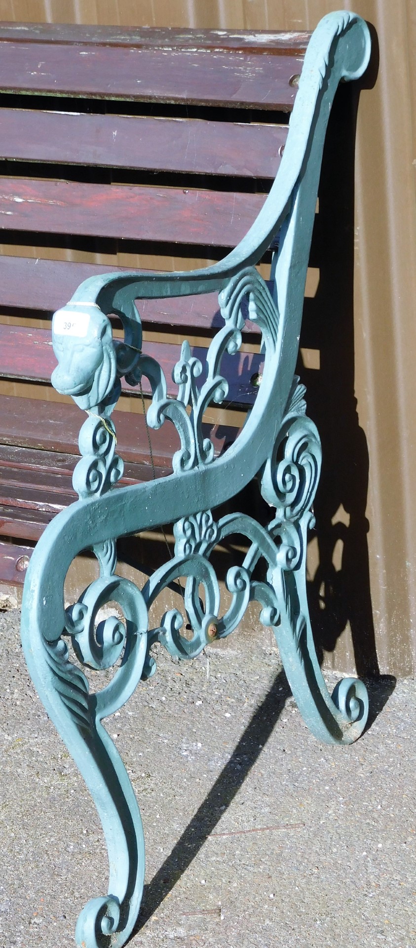 A cast iron and wooden slatted bench, the lion scroll supports painted green on wooden slats, 80cm h - Image 2 of 2