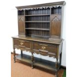 An oak mahogany dresser, the dresser top with carved fret above three shelves and two panelled doors