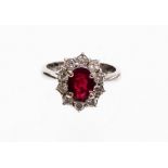 A ruby and diamond dress ring, with oval cut central ruby, 7.8mm x 6mm x 2.4mm, in a four claw setti