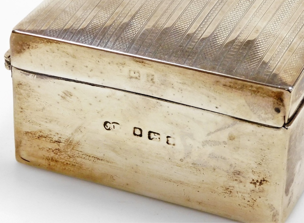 A silver table cigarette box, with vacant scroll cartouche to the hinged lid and engine turned decor - Image 2 of 2