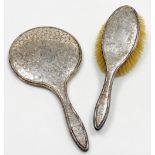 A George V silver backed heart dressing table set, comprising hand brush and mirror, each with embos