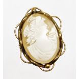 A late 19thC shell cameo brooch, with oval cameo depicting maiden, in a rolled gold scroll design ca