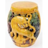 An early 20thC yellow green and brown glazed Chinese barrel seat, decorated with lions and trees, un