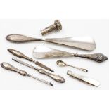 A group of silver handled effects, to include two silver handled shoe horns, one with cherub emblem,