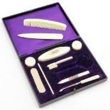 A simulated ivory manicure set, in fitted case with purple velvet interior.