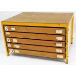 A plan chest, with applied pine effect plywood top, on yellow metal supports, with chipboard sides,