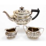 A Victorian silver three piece tea service, with ebonised handle and fluted body comprising teapot,
