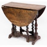 A 17thC oak drop leaf table, with twist design column pull out supports, and a two panelled top with