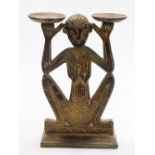 Tribal Art. A carved wooden figure holding two bowls, 51cm high, 30cm wide.