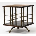 An Edwardian table top revolving bookcase, with oak top and brass sectional shelves, on three splaye