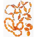 A group of orange hardstone beaded necklaces, to include one on string strand with yellow metal clas