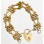 A 9ct gold gate bracelet, of four row and two row cross link design, with safety chain and a heart s