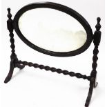 An oak barley twist dressing table mirror, with oval central mirror plate, on two barley twist colum