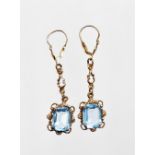 A pair of 10ct gold and aquamarine drop earrings, each with rectangular cut aquamarine in claw setti