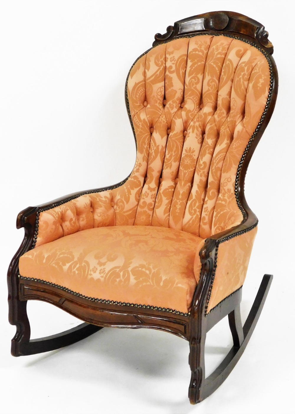A 19thC mahogany show frame swing back rocking chair, a pink floral upholstered button back, on rock