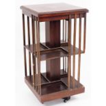 An Edwardian mahogany revolving bookcase, the top with fan parquetry inlay on two shelf section on c