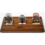 An early 20thC oak ink stand, with three cut glass ink wells, 35cm x 22cm.