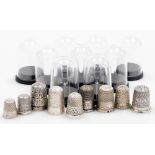 A group of nine silver thimbles, each of varying design, some in thimble cases, many by Charles Horn