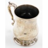 A George II silver baluster mug, with capped query handle, engraved initials 'M W', on stepped circu