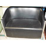A black leatherette two seater sofa with chrome supports and trims.