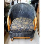 A blue wicker backed armchair with padded seat cushion.