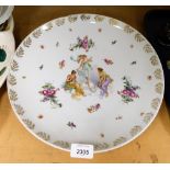 A continental porcelain charger, transfer printed with figures of maidens with a gilt border, 34cm d