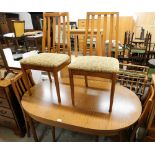 An oval extending kitchen table and four chairs. The upholstery in this lot does not comply with the