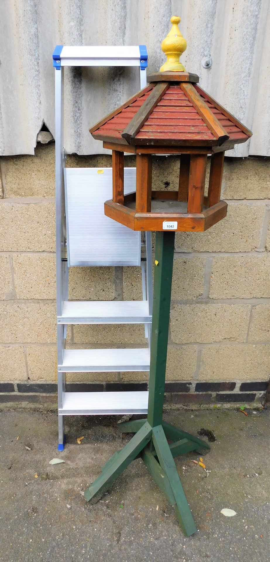 An aluminium step ladder and a bird table.