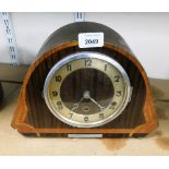 An Art Deco walnut cased mantel clock, in a shaped case with brass coloured dial, on bun feet, eight