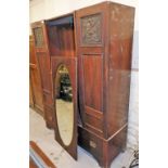 An Art Nouveau double wardrobe, lacking cornice with two Art Nouveau inlaid doors, and an oval mirro