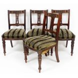 A set of four Edwardian walnut dining chairs, the backs with floral rosettes and leaves and berries,