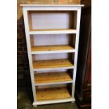 A white painted modern pine bookshelf, with five shelves.