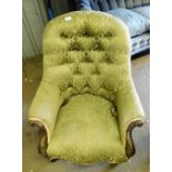 A Victorian button back armchair, the mahogany carved arms, with a gold ribbon border, on green dama